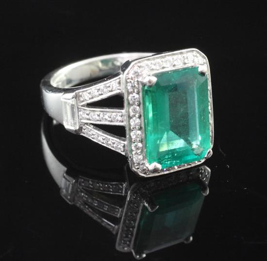 A platinum, emerald and diamond cluster ring, size L.